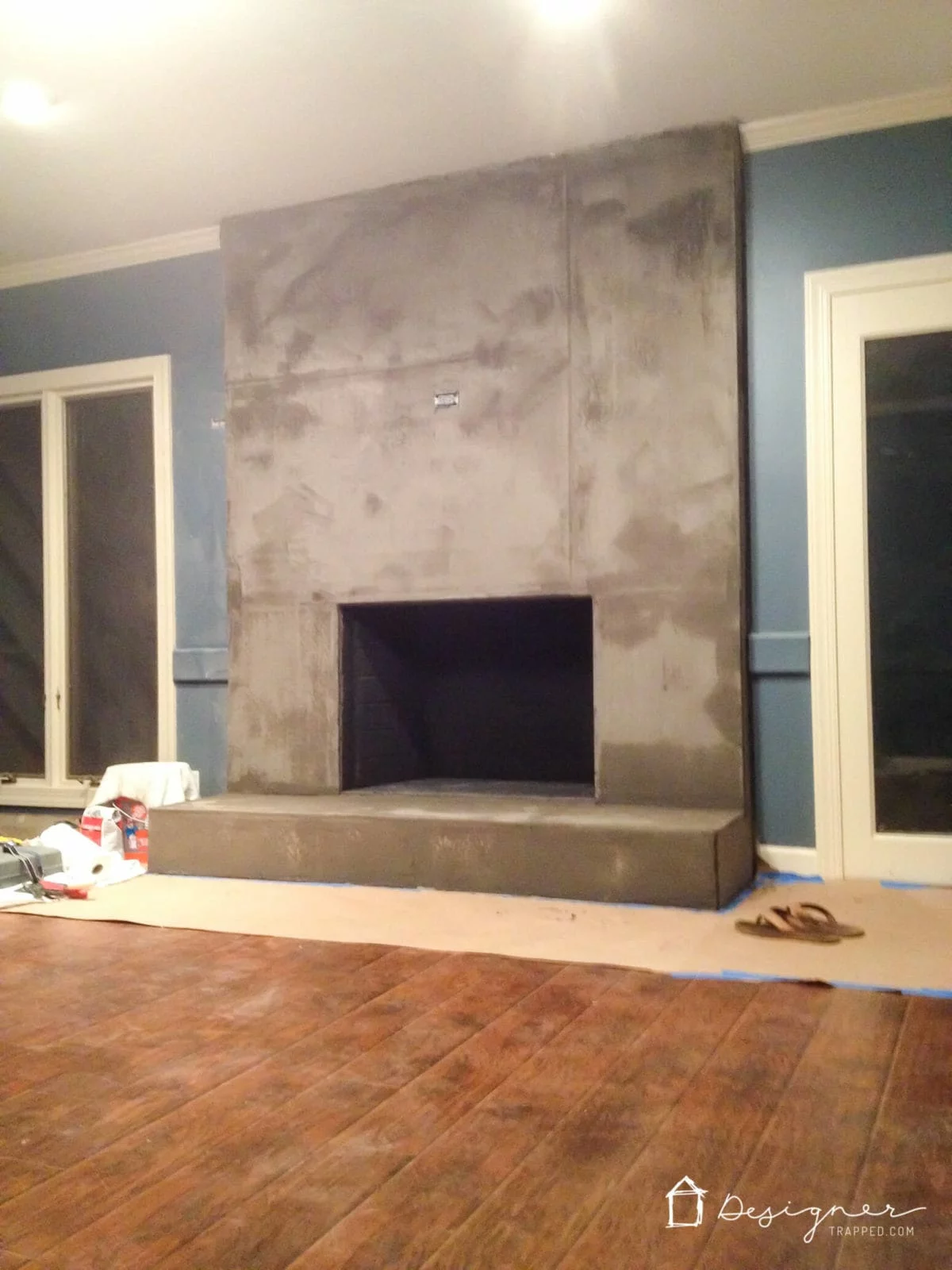 You can create a contemporary fireplace with concrete for less than $100. This full DIY concrete fireplace tutorial will show you exactly how!