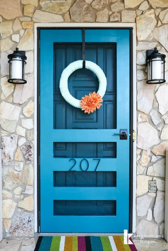 teal blue DIY screen door surrounded by stone