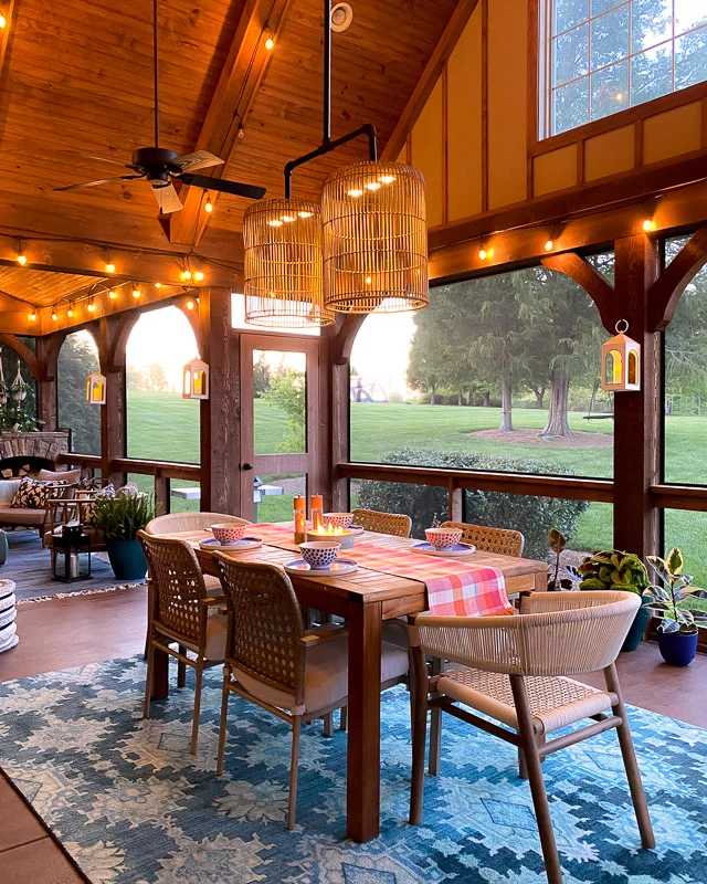 screened-in dining area with colorful table runner and rug