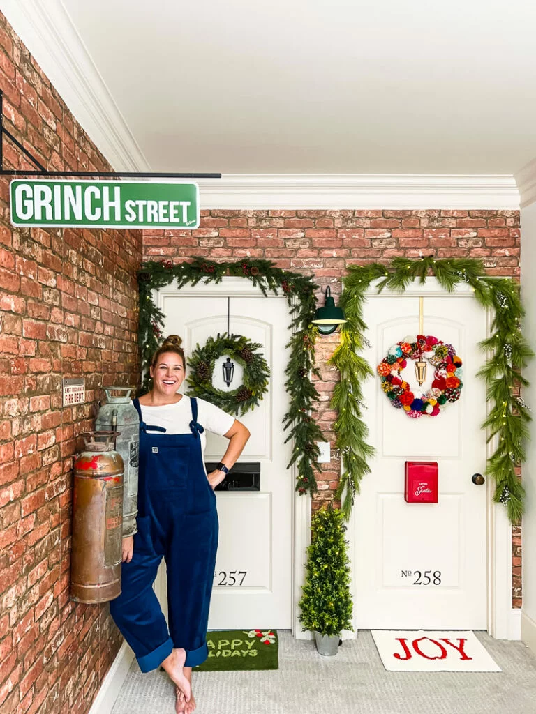 Tasha Agruso of Gadgetronicx standing in front of her daughters' bedroom doors that are decorated to look like apartment doors