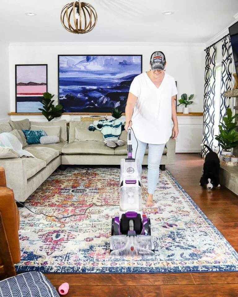 woman cleaning area rug with Hoover carpet cleaner