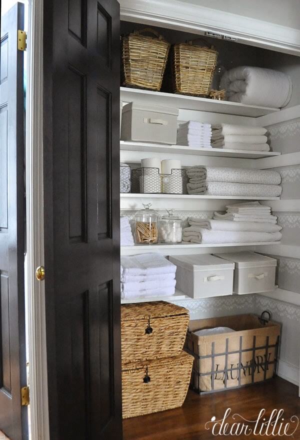 neatly organized linen closet with stenciling and neutral colors