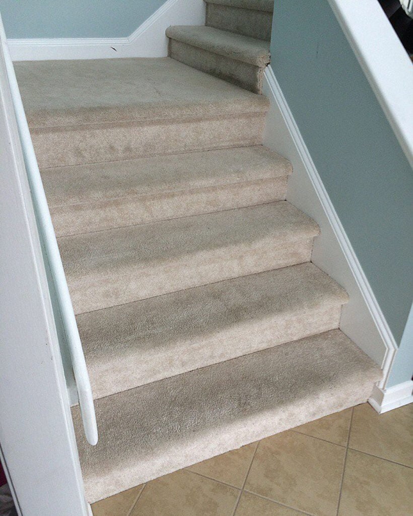 outdated stairs with beige carpeting