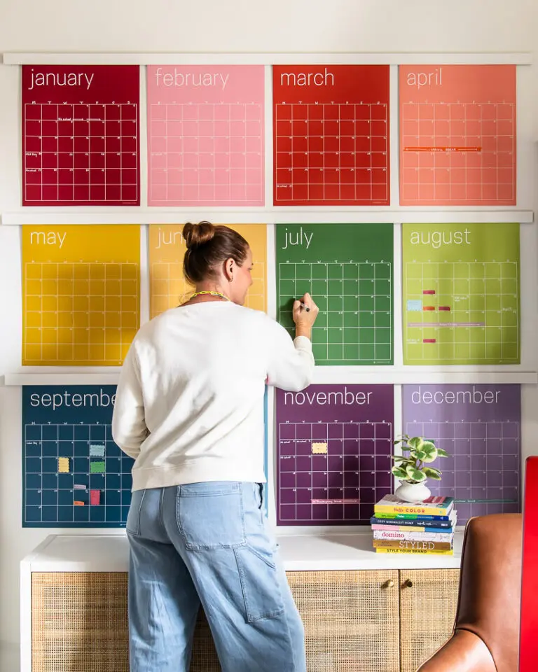 large colorful wall calendar hanging in office with faux poster hanging rails